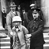  Photograph of the suffragette Fanny Parker, alias Janet Arthur, being escorted from Ayr Sheriff Court by a police officer. Miss Parker, a niece of Lord Kitchener, faced trial for attempting to burn Robert Burn's cottage in Alloway, 1914 (Crown Copyright, National Records of Scotland, HH16/43/58)