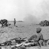 Photograph of a Royal Field Artillery Battery in action with an Indian sepoy in the left foreground in Mesopotamia, circa 1917 (Crown Copyright, National Records of Scotland, GD372/288/11)