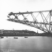 Photograph of the Fife S Cantilever of the Forth Railway Bridge under construction reaching over the Forth to the north shore covered on steam cranes and hoists, 24 May 1889 (Crown Copyright, National Records of Scotland, BR/FOR/4/34/49) 