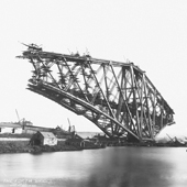 Photograph of the incomplete Forth Railway Bridge from the north west, Fife pier in the foreground, Inchgarvie and Queensferry beyond. Cantilevers almost completed but central girders not commenced, 22 March 1889 (Crown Copyright, National Records of Scotland, BR/FOR/4/34/223) 