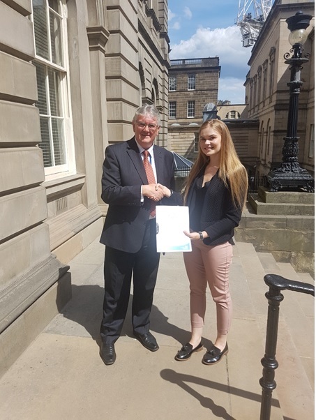 Image- Lindsay Turpie, Records and Information Management Officer for Dumfries and Galloway Council, is pictured handing over the RMP to Hugh Hagan, Senior Public Records Officer of the Assessment Team.